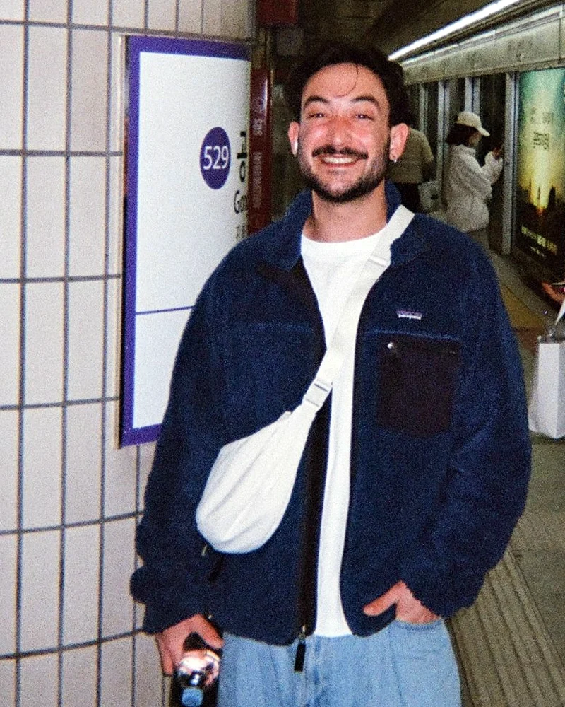 Ariel Romanovich smiling on a subway platform